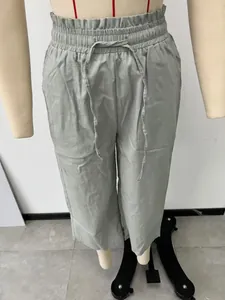 Close-up detail of the elastic paper-bag waist and adjustable drawstring on sage linen pants