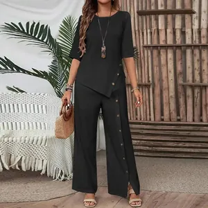 Detail view of black two-piece set with asymmetrical buttoned hem and wide-leg pants