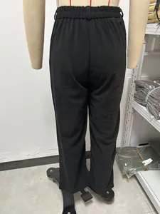 Gedetailleerd achteraanzicht van zwarte corduroy broek met hoge taille op een paspop