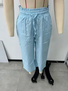 Close-up showing the elastic drawstring waist of light blue linen wide-leg trousers.