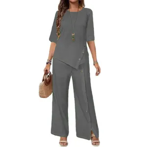 Detail of grey two-piece set featuring asymmetrical button shirt and wide leg pants