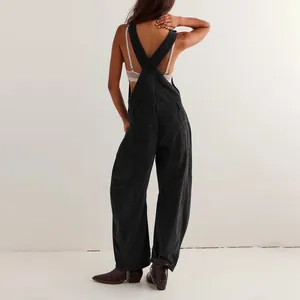 Vista trasera de peto de pana negra para mujer con perneras anchas y tirantes cruzados