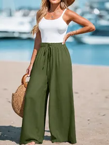 Detail view of green cotton linen wide-leg pants with functional drawstring waist.