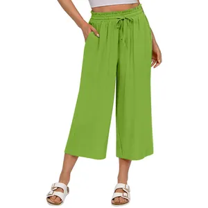 Close-up of green high-waisted linen wide-leg pants with elastic drawstring waist design.