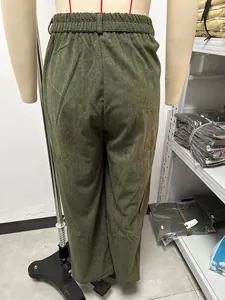 Gedetailleerd achteraanzicht van de olijfgroene ribfluwelen broek met hoge taille op een paspop