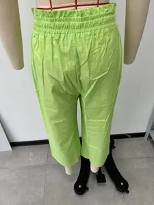 Detailed back view of the elastic waistband on lime green linen wide-leg trousers
