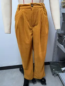 Detailopname van een mosterdgele corduroy broek met hoge taille en rechte pijpen