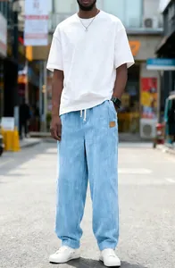 Full view of light blue men's corduroy drawstring pants in a casual street setting.