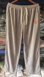 Detail view of grey corduroy men's straight trousers with drawstring waist.