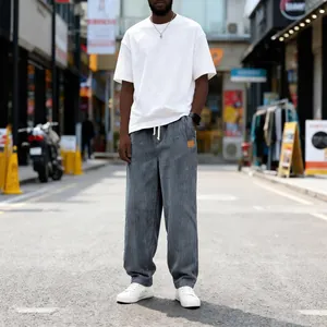 Urban street style shot of men's loose fit grey corduroy drawstring casual trousers
