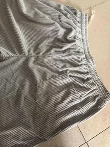 Detail view of men's corduroy pants showing waist drawstring and pocket texture.