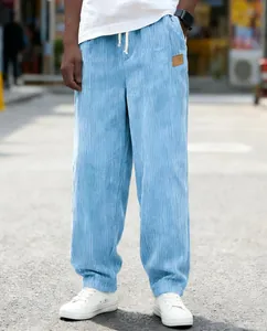 Close-up of men's blue corduroy pants with drawstring and loose fit for casual street style wear.