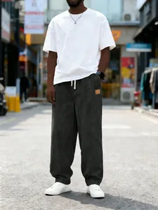 Street style view of men's loose corduroy trousers with drawstring waist and patch