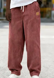 Detail view of men's rust corduroy drawstring pants showing fabric texture
