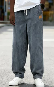 Close-up of men's loose fit grey corduroy trousers with drawstring and soft fabric texture