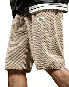 Close-up of textured jacquard pattern and woven label on beige casual shorts