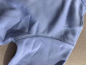 Gros plan sur la couture double résistante d'un sweat-shirt bleu clair épais doublé.