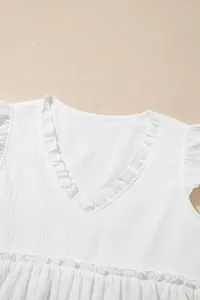 Nahaufnahme des weißen V-Ausschnitts mit Rüschen und filigraner Stoffstruktur-Details.