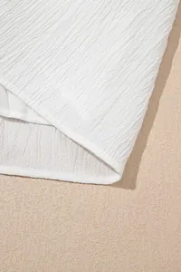 Nahaufnahme des weißen, gekräuselten Stoffes eines eleganten Langarm-Oberteils