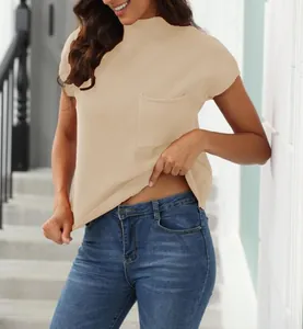 Close-up detail of a beige ribbed mock neck short sleeve sweater with a functional pocket
