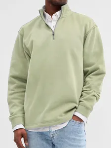 Close-up of sage green men's quarter-zip sweatshirt with stand collar detail