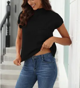 Detail view of black mock neck ribbed knit top on a model standing outdoors.