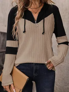 Primo piano della maglia con cappuccio bicolore con scollo a zip e trama a coste.