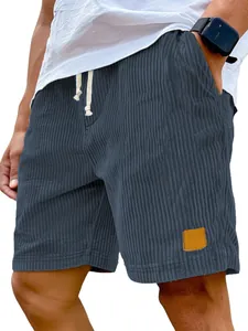 Detail view of men's blue corduroy shorts with drawstring and leather patch.