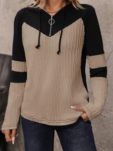 Dettaglio felpa con cappuccio in maglia bicolore da donna con scollo a zip e coste.