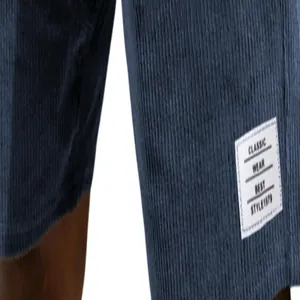 Detail view of blue corduroy shorts featuring a classic white stitched label patch.