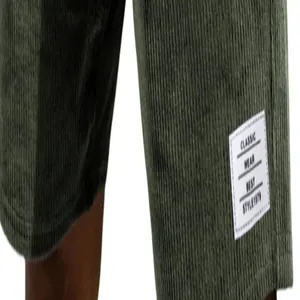 Close-up of green corduroy shorts for men featuring a decorative white fabric label.