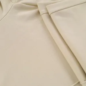 Detalle de primer plano de pantalones de punto beige para hombre, textura de tela premium.