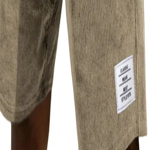 Macro close-up detail of white woven label on men's khaki corduroy shorts leg cuff