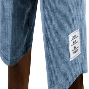 Close-up of light blue corduroy men's shorts with classic white fabric tag on leg hem.
