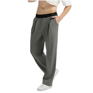 Vista lateral de pantalones casuales grises para hombre con cintura elástica negra y calzado