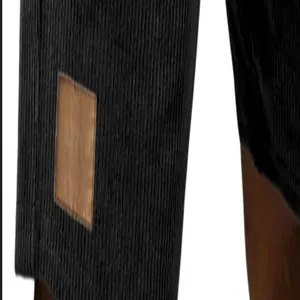 Nahaufnahme des Leder-Patches und des Cordgewebes an diesen schwarzen Herren-Shorts.
