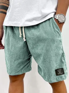 Détail du short en velours côtelé vert menthe pour homme avec étiquette noire et cordon