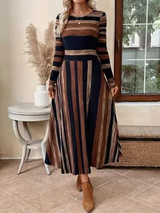 Full-body view of a striped long-sleeved maxi dress with cinched waist and large swing hem