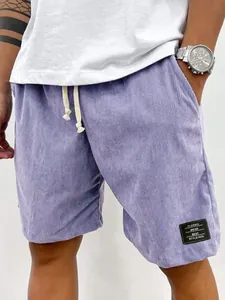 Détail du short en velours côtelé violet pour hommes avec cordon et écusson textile noir