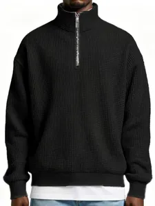 Detailed view of men's black waffle knit pullover with quarter zip and stand collar