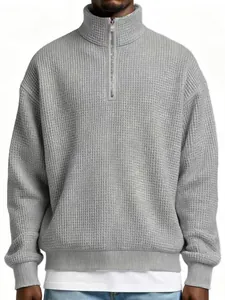 Close-up of a grey textured waffle-knit quarter-zip sweatshirt for men in a loose fit