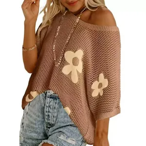 Detailansicht einer locker gestrickten Blumen-Jacquard-Bluse an einem Modell auf weißem Grund