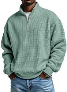 Close-up of men's sage green waffle knit quarter-zip sweatshirt with ribbed cuffs.
