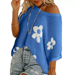 Detail des blau geschlitzten Stricküberwurfes mit weißem Blumen-Jacquard