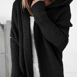 Close-up of black oversized hooded knitted cardigan featuring textured batwing sleeves