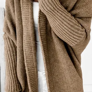 Close-up detail of a brown knitted cardigan featuring batwing sleeves and textured knit pattern.