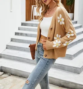 Dettaglio del cardigan in maglia kaki oversize con motivi floreali a margherita bianchi
