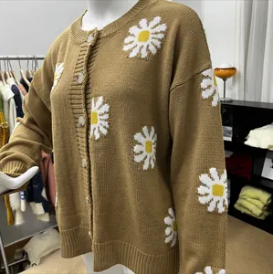 Detailaufnahme eines braunen Strickcardigans mit weißen Gänseblümchen-Stickereien