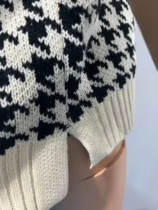 Detailaufnahme einer klassischen schwarz-weißen Strickweste mit Hahnentrittmuster und Seitenschlitz
