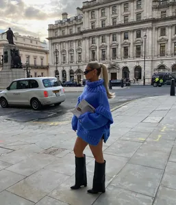 Street style view of a vibrant blue chunky knit turtleneck oversized sweater